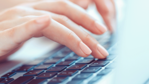 woman's hands typing on keyboard