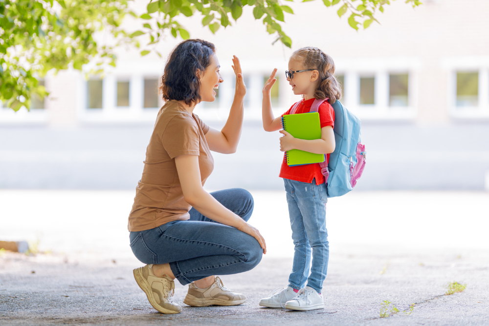 Mom and daughter give each other high five on the way to school