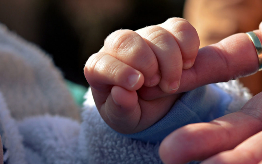 baby holding grandmother's finger