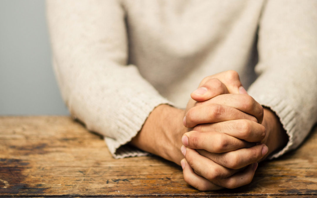 adult praying with hands folded
