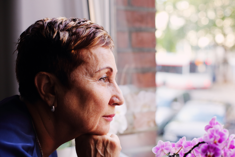 Mature woman staring out of a window