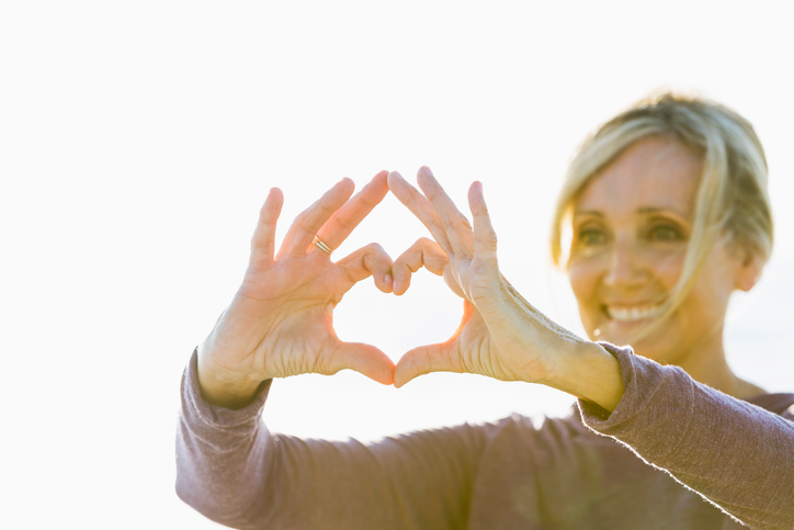Mature woman with hands in shape of heart