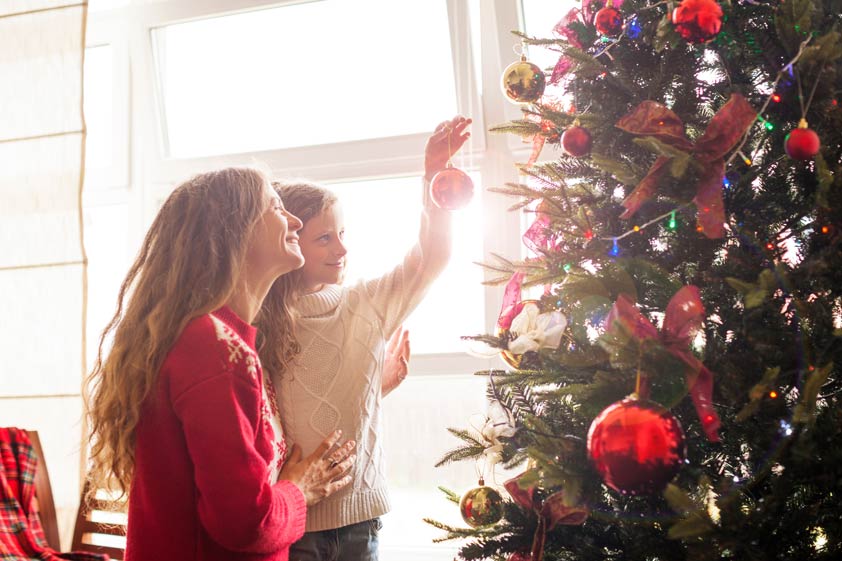 Mother and daughter decorating the tree