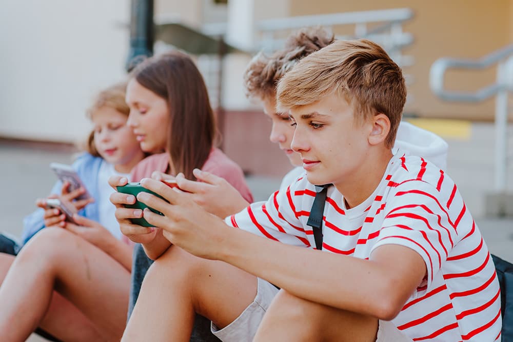 boy-plays-mobile-game-with-friends