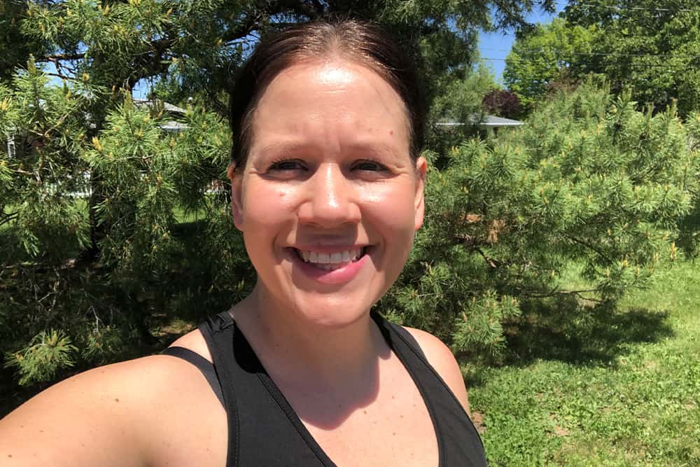 Woman outside in workout tank top smiling for a selfie