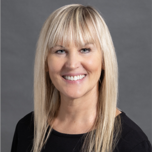 Acupuncturist at Bryan Health The Spa Betsy Degrandi headshot with blonde hair and bangs wearing a black long-sleeve shirt