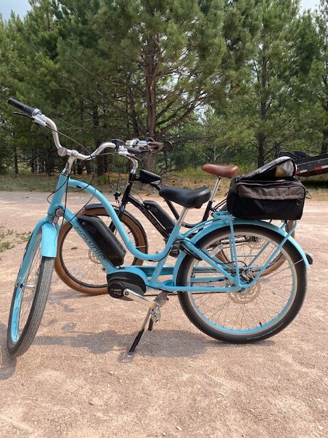 Blue vintage ebike in foreground with black ebike in background on Nebraska to Colorado ride