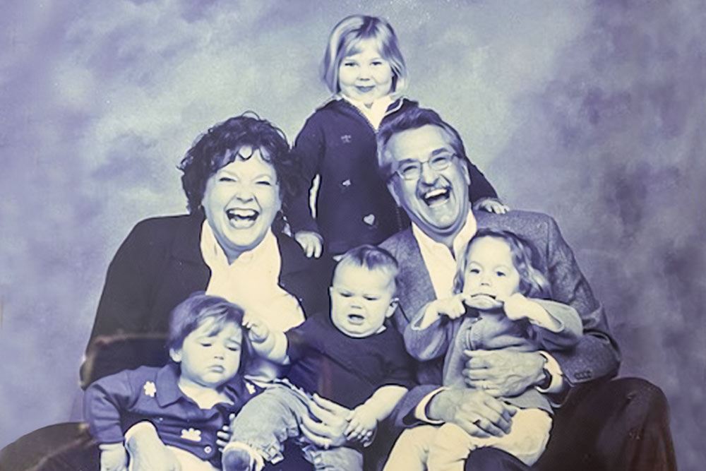 Nancy and her husband John posing for family photo with their four grandchildren when they were toddlers