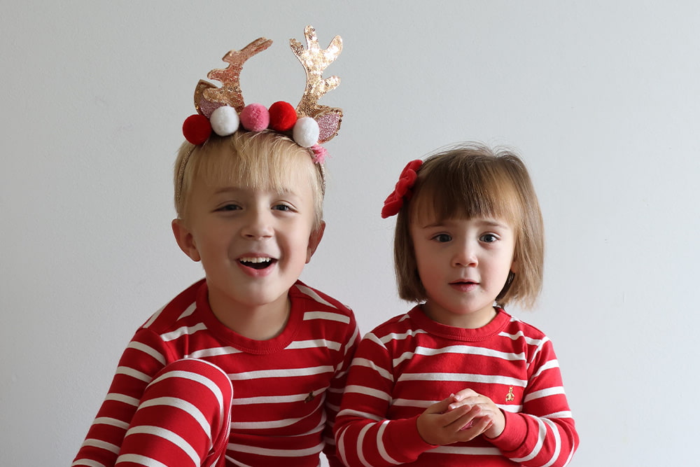 Cassidy's son and daughter posing for a holiday photo while wearing red and white striped pajamas